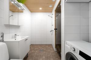 a white bathroom with a sink and a washing machine at Apartment Aurinkoranta D5 saunallinen kaksio merinäkymällä Kalajoki in Kalajoki +4 photos