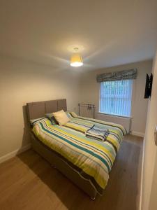 a bed with a striped blanket in a bedroom at CamCosy Retreat in Gortin