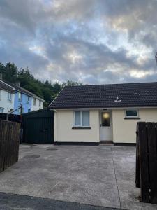 a white house with a black roof and a driveway at CamCosy Retreat in Gortin