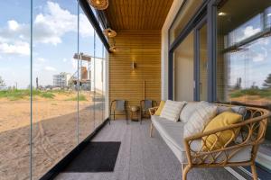 a screened in porch with a couch on the beach at Apartment Aurinkoranta D5 saunallinen kaksio merinäkymällä Kalajoki in Kalajoki