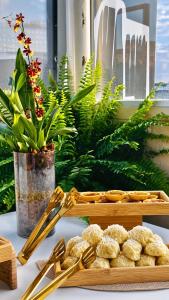 a table with gold utensils and a tray of food at Hotel Aconchegante in Jequié