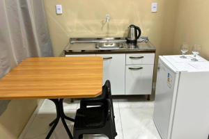 a small kitchen with a table and a stove at Chalés EduCarMo in Ametista do Sul