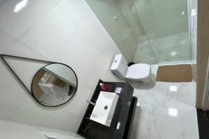 a bathroom with a mirror and a toilet at Chalés EduCarMo in Ametista do Sul +19 photos