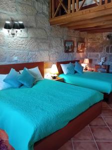 a bedroom with two beds with green sheets at Casa Major in Pegarinhos