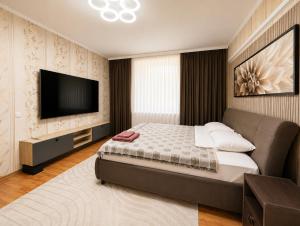 a bedroom with a bed and a flat screen tv at Apartment Casa de Bruja in Drochia