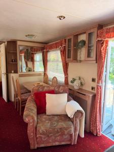 a living room with a couch and a table at Swans Rest - Lakeside Caravan Park in Denver