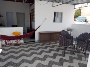 a room with chairs and a table and a hammock at recanto sossego in Garanhuns