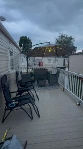 a patio with two chairs and an umbrella on a deck at Casa Dana in Jaywick Sands
