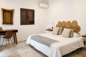 a bedroom with a bed with a wooden headboard and a desk at Casa Areka in Brisas de Zicatela