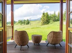 a screened porch with chairs and a view of a field at Chalet Mates in Ždiar
