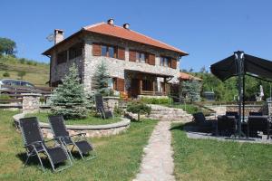 a stone house with chairs in front of it at nKulle in Boge