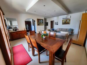 a dining room and living room with a table and chairs at Spacious Poolside Apartment with Patio 11A2S in Għajnsielem