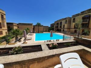a view of a swimming pool in a building at Spacious Poolside Apartment with Patio 11A2S in Għajnsielem