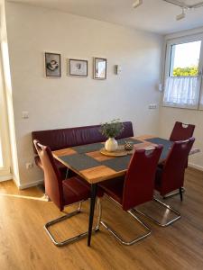a dining room with a table and red chairs at FeWo Auszeit eigene große Terrasse mit Strandkorb und Grill in Wesel