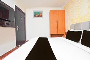 a bedroom with a black and white bed and a cabinet at Hotel O The Arrow in New Delhi +21 photos