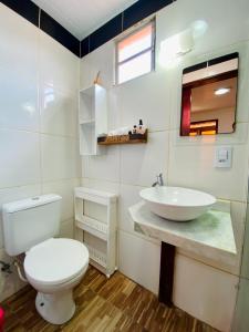 a bathroom with a white toilet and a sink at Pousada São Pedro in Flecheiras +96 photos