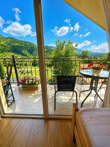 a room with a balcony with a table and a view at cottage in tsemi (Borjomi) in Borjomi