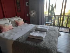 a bedroom with a large bed with two towels on it at Entendeni Lodge SelfCatering in Inanda +25 photos