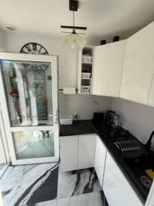 a kitchen with white cabinets and black counter tops at Mieszkanie Ratownika in Dziwnów +13 photos