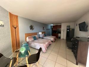 a bedroom with two beds and a television in it at By the sea Condominium in San Carlos
