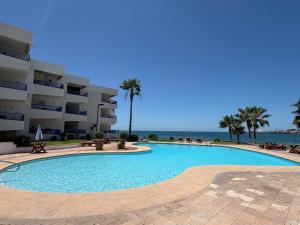 a large swimming pool in front of a building at By the sea Condominium in San Carlos