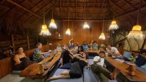 a group of people sitting around a table in a room at Wave Hunters Arugam Bay in Arugam Bay