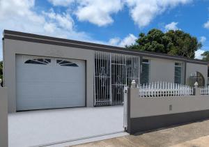 a house with a white fence and a garage at Sun Seekers Retreat 3 bedrooms in Santa Maria