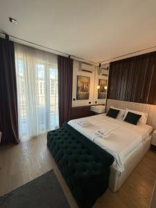 a bedroom with a large bed with a green couch at BW LUX STUDIO-Belgrade Waterfront in Belgrade