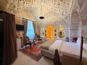 a bedroom in a castle with a bed and a table at Mirisso Konağı MARDİN in Mardin