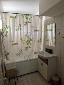 a bathroom with a shower curtain with plants on it at Apartament Central Pietonalul Unirii in Botoşani