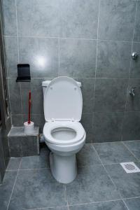 a bathroom with a white toilet in a tiled room at Onkundis Luxury Homes in Kiambu