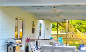 a white house with a patio with a table and chairs at Luxe Dream Beach House in Gulfport