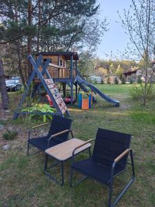 two chairs and a playground with a slide at Stacja Roztocze in Majdan Kasztelański +6 photos
