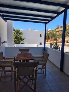 a table and chairs on a balcony with a view at Deilino - Olive View Studio in Amorgos +1 photo
