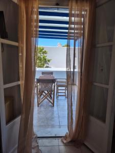 a room with a view of a table and a window at Deilino - Olive View Studio in Amorgos