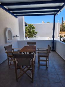 a patio with tables and chairs on a roof at Deilino - Olive View Studio in Amorgos