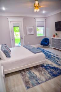 a bedroom with a bed and a blue chair at Luxe Dream Beach House in Gulfport +37 photos