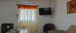 a room with a curtain and a television on a wall at Palo Blanco in Cinco Saltos