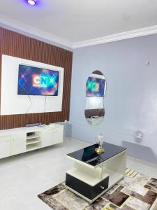 a living room with a tv and a table at Legacy apartments in Ikeja