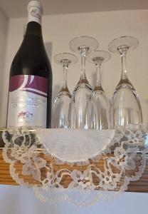 a bottle of wine and four wine glasses at L'Albore in Costigliole Saluzzo