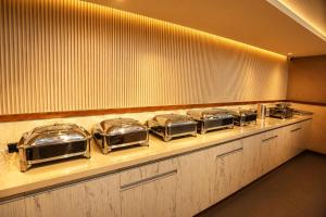 a buffet line with several trays of food at The Signature Munnar in Munnar