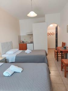 a hotel room with two beds and a table at Deilino - Side View Studio in Amorgos