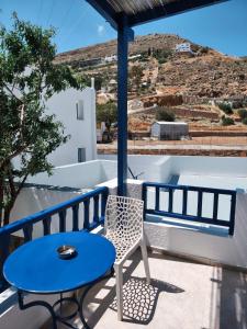a blue table and a chair on a balcony at Deilino - Side View Studio in Amorgos