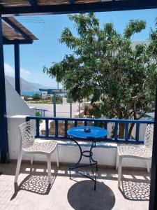 a table and chairs on a balcony with a view at Deilino - Side View Studio in Amorgos