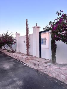 a white building with a garage with flowers on it at شاليه الجاكرندا 8 in Taif