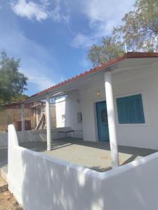 a white house with a blue door and a fence at Casa de Playa in Salamina