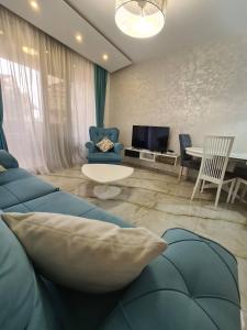 ein Wohnzimmer mit einem blauen Sofa und einem Tisch in der Unterkunft Petrus in Rafailovici