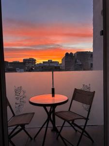 a table and chairs on a balcony with a sunset at AG SUITE TRAPANI in Trapani