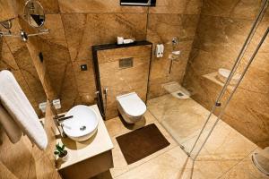 a bathroom with a shower and a toilet and a sink at The Signature Munnar in Munnar +9 photos