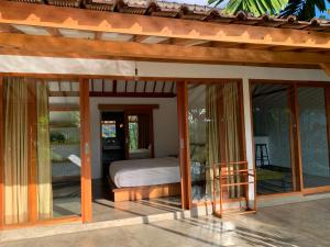 a room with glass doors and a bed on a patio at Villa YAMI Uluwatu Private Infinity Pool Jungle Views in Ungasan +16 photos